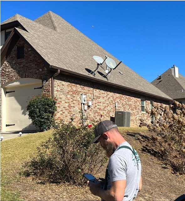 Tyler Roofing on-site, checking a brick home's roof during a free inspection