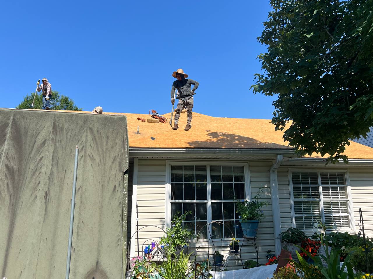 Tyler Roofing crew tearing off old shingles on a brick home